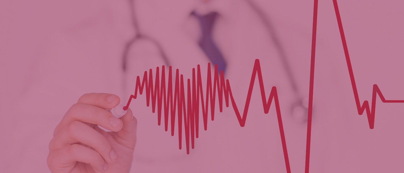 A doctor draws a cardiograph connecting to a heart with a red marker