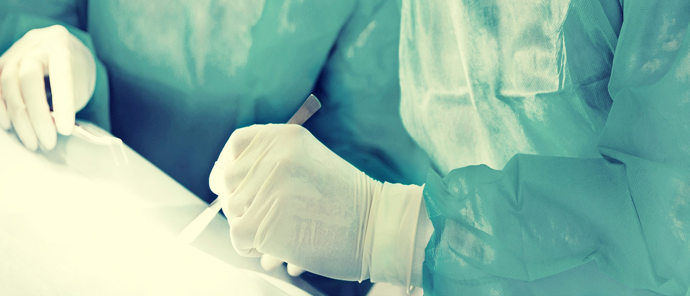 Medical professionals wearing scrubs and gloves. Close up on their hands.